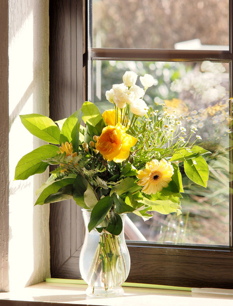 Blumen in Glasvase am Fenster